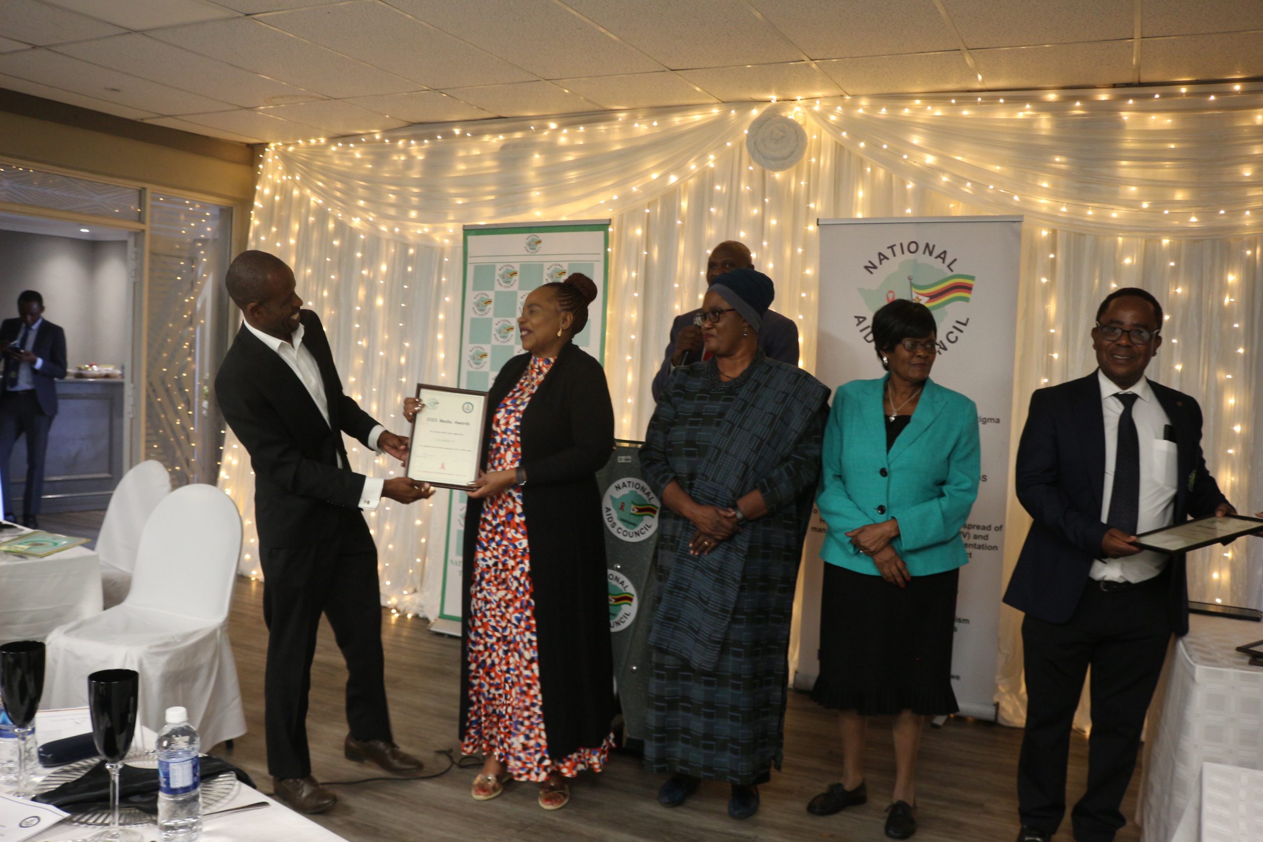 Information minister Mutsvangwa handing over an award to a journalist